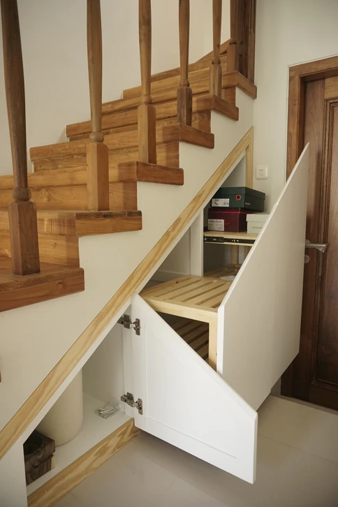 Intérieur résidentiel avec escalier escamotable déployé donnant accès aux combles