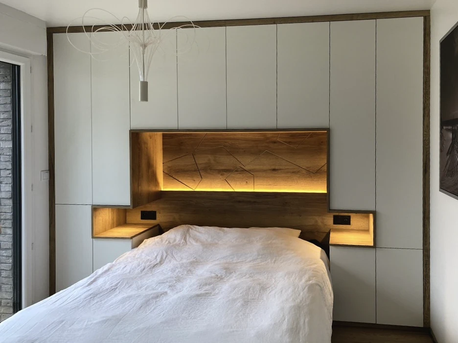 Chambre moderne avec tête de lit intégrée dans un ensemble de rangements muraux