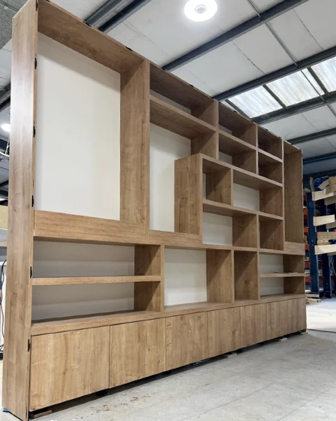 Atelier de menuiserie industrielle avec bibliothèque modulaire en bois massif en cours de fabrication
