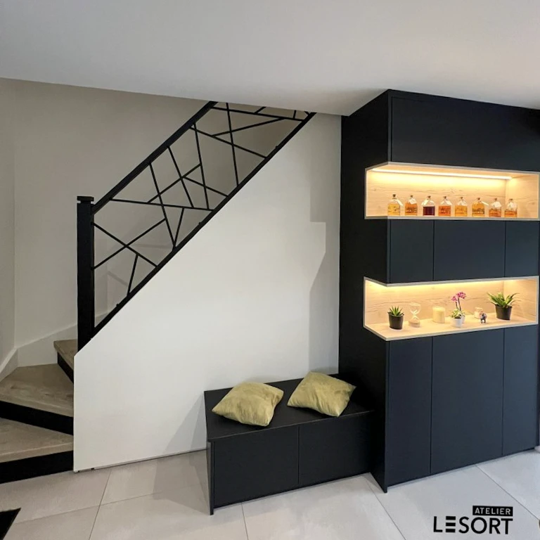 Cuisine moderne avec plan de travail noir en pierre naturelle, façades en bois clair, évier noir intégré avec égouttoir rainuré