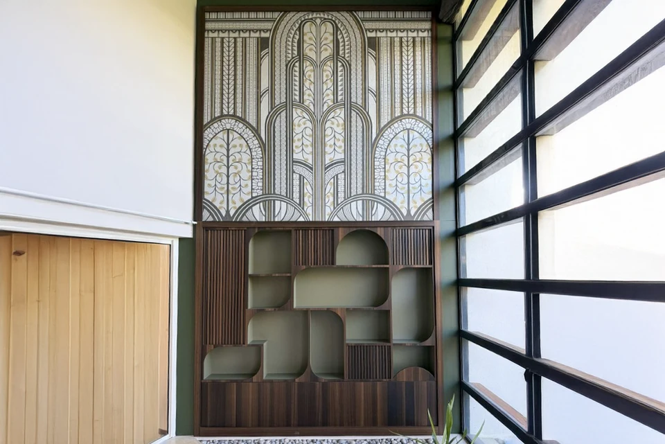 Chambre moderne avec dressing ouvert intégré au mur, lit double avec linge gris et blanc, fauteuil design nordique